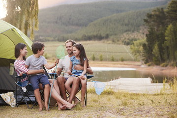 Family Enjoying Camping Vacation By Lake Together