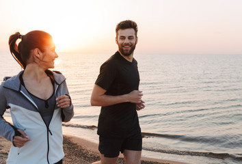 Canvas Print - Smiling young couple jogging together