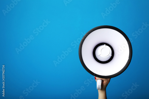 Fotografia, Obraz Female hand holding megaphone on blue background