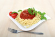 Spagetti z sosem bolońskim serem, pomidorami i zielonymi listkami bazyli i pietruszką.
