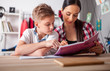 © leszekglasner - Mother helping her son with homework in teenage room at home