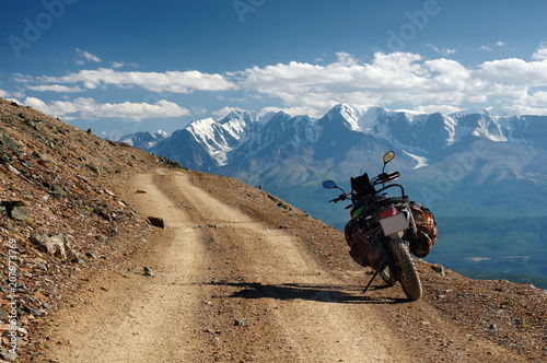 Fotografía Motorcycle enduro traveler with suitcases standing alone on yellow stone extreme