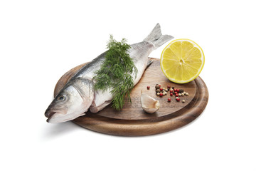 Uncooking fish with lemon, herbs and spices on wooden plate, isolated on white background