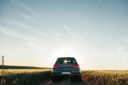 Photographie Car in the field in summer sunset
