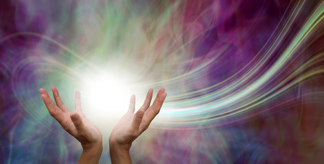 stunning healing energy phenomenon - female hands reaching up into a ball of white energy with a las