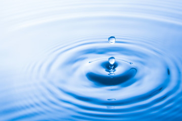  Water drop falling into water make waves. Water splash or water drop background.