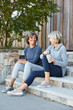 © Trinette Reed/Stocksy - Senior women friends relaxing and talking after a run together sitting on steps