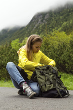 Woman Sitting And Searching In Backpack