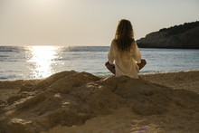 Young Woman Practicing Yoga At The Beach, By Sunrise