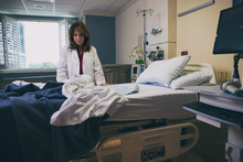Hospital: Upset Doctor Stands Quietly Over Empty Patient Bed