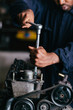 © kkgas/Stocksy - Mechanic fixing an engine for a head gasket repair in a garage.