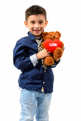 Studio shot of cute happy boy smiling and holding teddy bear wit