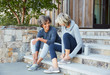 © Trinette Reed/Stocksy - Senior women friends relaxing and talking before a run together sitting on steps
