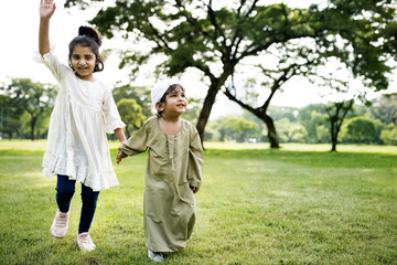 Wall Mural - Muslim brother and sister playing in the park