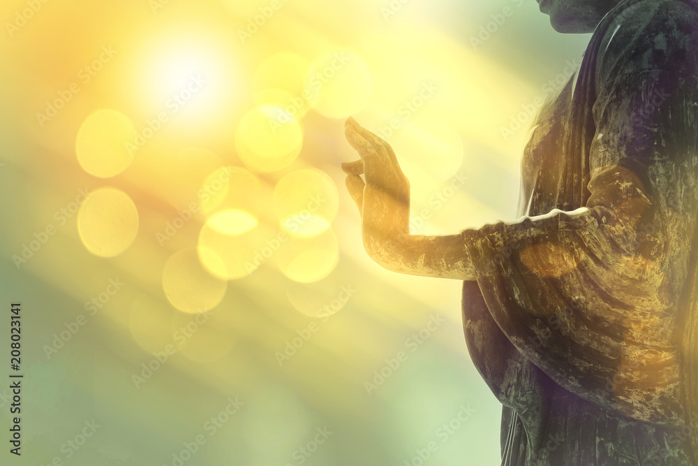 hand of buddha statue with yellow bokeh background, light of wisdom and concentration concept - obrazy, fototapety, plakaty 