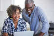 © Trinette Reed/Stocksy - Senior African American couple using a computer in the kitchen together
