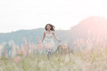 Beautiful woman enjoying meadow field, nice female lying down in meadow of flowers, pretty girl relaxing outdoor, having fun, holding plant, happy young lady and spring green nature, harmony concept