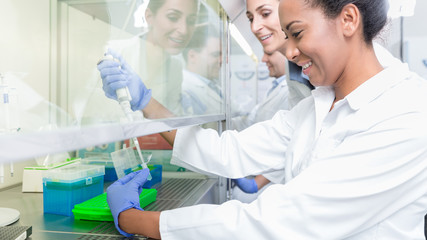 Group of scientists in research laboratory working under splashback