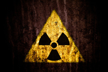 Wall Mural - Radioactive (ionizing radiation) danger yellow symbol over a massive cracked concrete wall with and dark rustic grunge brown texture background.