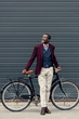 © LIGHTFIELD STUDIOS - stylish mature african american man in burgundy jacket posing near bicycle