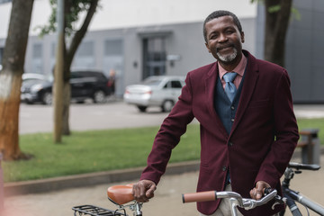 Wall Mural - smiling african american man with bicycle in city