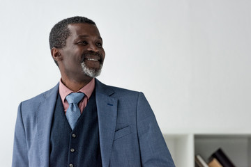 Wall Mural - stylish smiling african american man in blue jacket