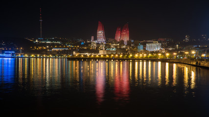 Wall Mural - Baku night cityscape with flaming towers and reflections in the Caspian sea bay