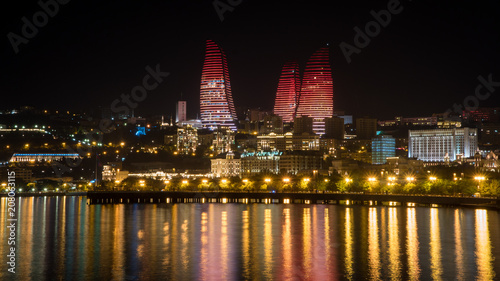 Fotomural Baku night cityscape with flaming towers and reflections in the Caspian sea bay