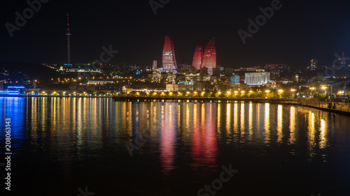 Cuadros en Lienzo Baku night cityscape with flaming towers and reflections in the Caspian sea bay