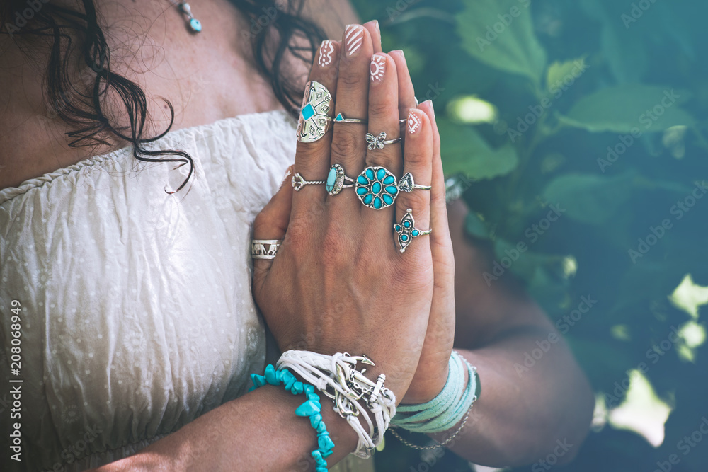 Obraz na płótnie close up of yoga woman hands in namaste gesture with lot of boho style jewelry rings and bracelets outdoor w salonie