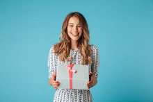 Happy blonde woman in dress holding gift box