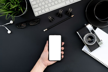 Fototapete - Flat lay of top view Business woman use smartphone on modern black desk work table with computer laptop,retro film camera and stationary in home office includes copyspace for add text or graphic