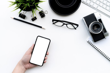 Wall Mural - Flat lay of top view Business woman use smartphone on modern white desk work table with computer laptop,retro film camera and stationary in home office includes copyspace for add text or graphic