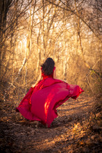 Girl In Red Dress Running Through Woods