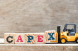 Toy forklift hold letter block X in word capex (abbreviation of capital expenditure) on wood background