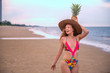 © May Chanikran - Portrait happy woman with long blonde curly hair holding pineapple on the beach with enjoying and refreshing, summer beach relaxing time concept.