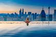 Young woman in a roof top swimming pool with beautiful city view. Vacation in Kuala lumpur, Malaysia