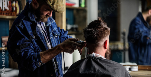 Barber With Clipper Trimming Hair Of Client Rear View Hipster