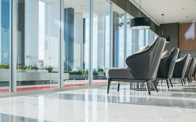 Row of chairs in executive office waiting room. background outdoor modern lobby big window and blue sky with clouds.