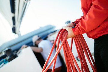 Canvas Print - Young handsome sailor pulling rope on sailboat