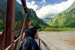 Young female tourist crosses a railway bridge towards Machu Picchu