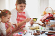 © grki - Happy Family in the Kitchen. Mother and Daughter Backing Cakes.