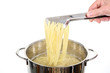 Wyjmowanie gotującego się makaronu spagetti z metalowego garnka.