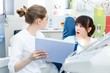© pantovich - Woman dentist shows the patient the bad results of the examination in the dental clinic