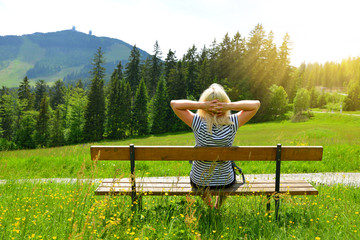 Wall Mural - tourist sitting on a bench overlooking the mount grosser arber in national park bayerische wald, ger