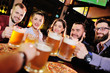 © Evgeniy Kalinovskiy - happy cheerful friends drink draft beer and clink glasses in a bar or pub