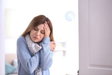 Woman with headache suffering from cold on blurred background