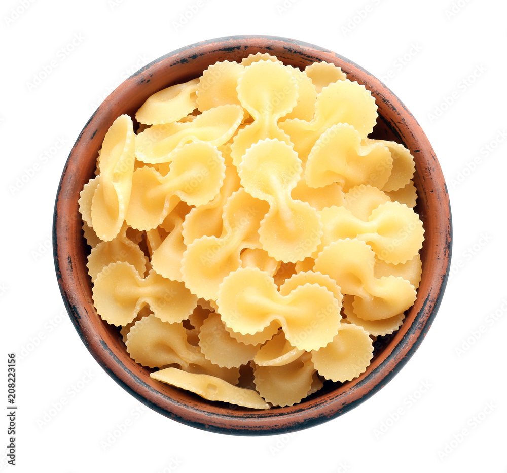 Bowl with raw pasta on white background