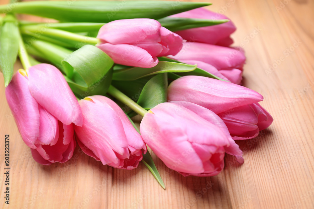 Beautiful fresh tulips on wooden background, closeup