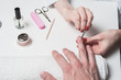 Men's manicure. hands of the beautician treated cuticle of male hands using pusher, scraper